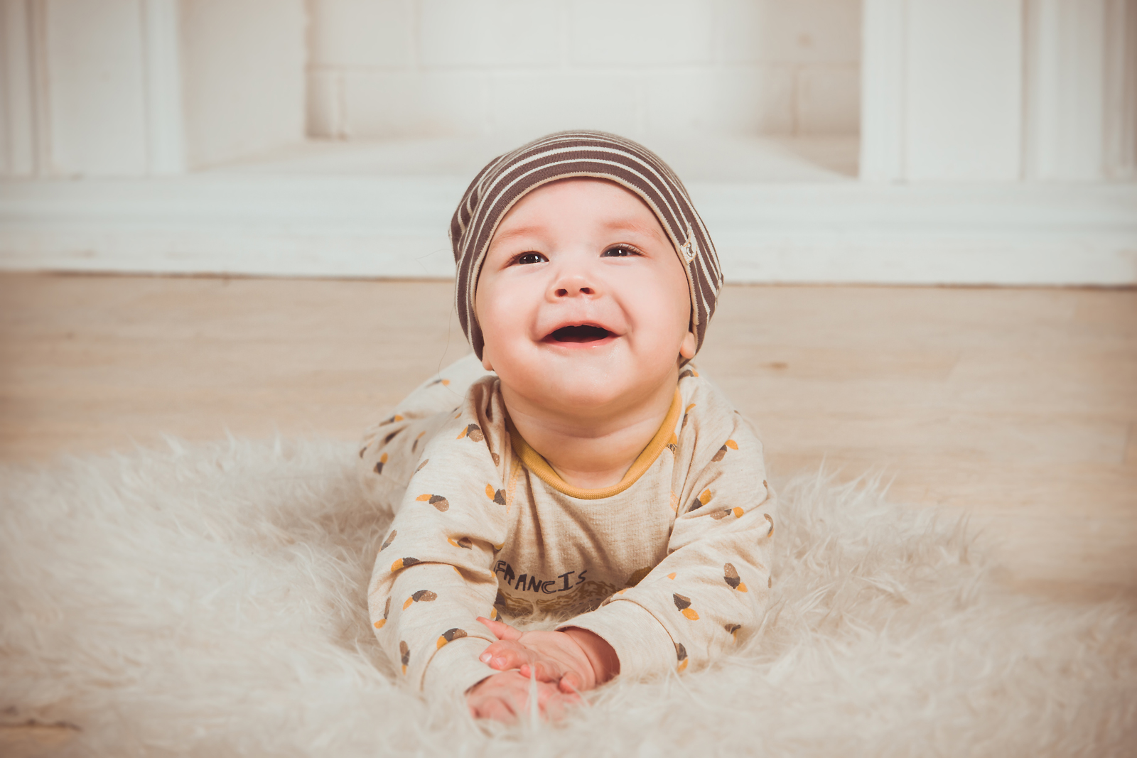 A baby laying on a fluffy rug