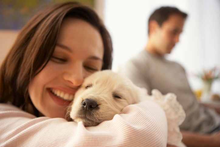 A woman hugging a young puppy