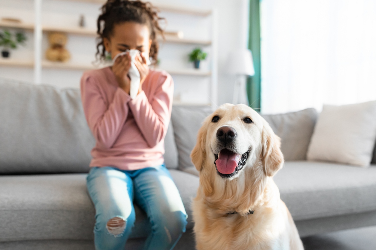 girl sneezing next to dog