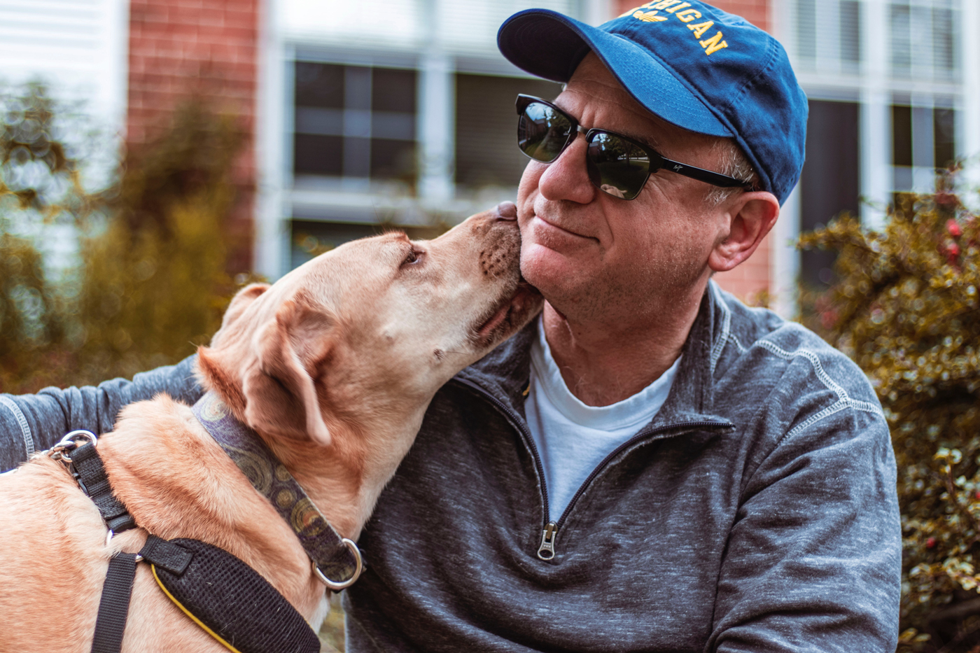 A man in his fifties and his pet dog sitting down while out on a walk